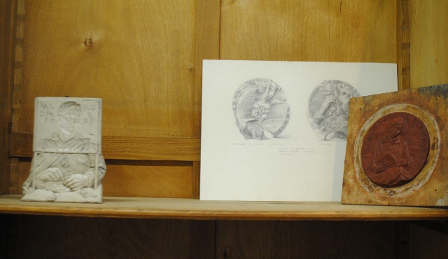 A la izda.: Plaqueta del 150 Aniversario de la Caja de Ahorros y Monte de Piedad En el centro: Proyecto de medalla Energa y vida. Congreso en Madrid A la dcha.: Original en plastilina de la medalla de la Real Academia de la Lengua.