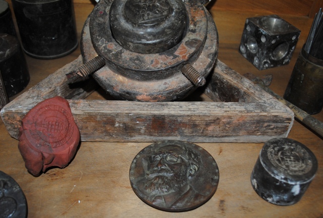 De detrs a delante y de izda. a dcha.: til para el cincelado de punzones y troqueles. Molde para el batido de metal. Registro de troquel. Ejemplar acuado. Troquel Complutense