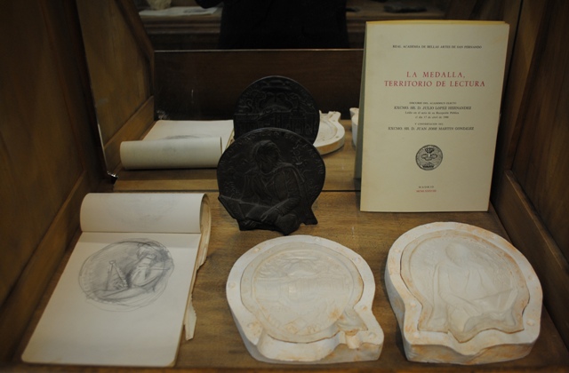 De detrs a delante y de izquierda a derecha:  Ejemplar en bronce de la medalla para la Universidad de Alcal de Henares Discurso de ingreso en la Real Academia de Bellas Artes de San Fernando Cuaderno de esbozos Moldes de silicona para fundir a la cera p
