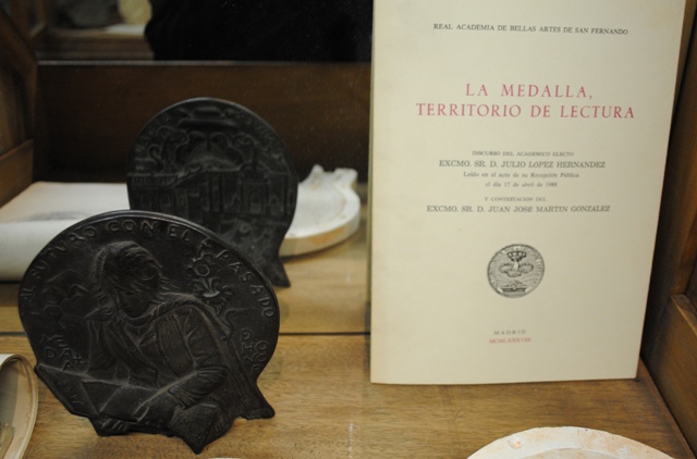 De detrs a delante y de izquierda a derecha:  Ejemplar en bronce de la medalla para la Universidad de Alcal de Henares Discurso de ingreso en la Real Academia de Bellas Artes de San Fernando