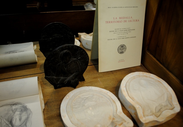 De detrs a delante y de izquierda a derecha:  Ejemplar en bronce de la medalla para la Universidad de Alcal de Henares Discurso de ingreso en la Real Academia de Bellas Artes de San Fernando Cuaderno de esbozos Moldes de silicona para fundir a la cera p